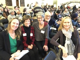 a group of five smiling climate leaders at the Chicago Climate Summit in 2017 at the Field Museum
