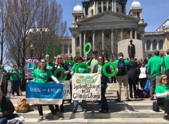 climate reality leaders in outside the Capital Building in Springfield, IL holding signs and green rings